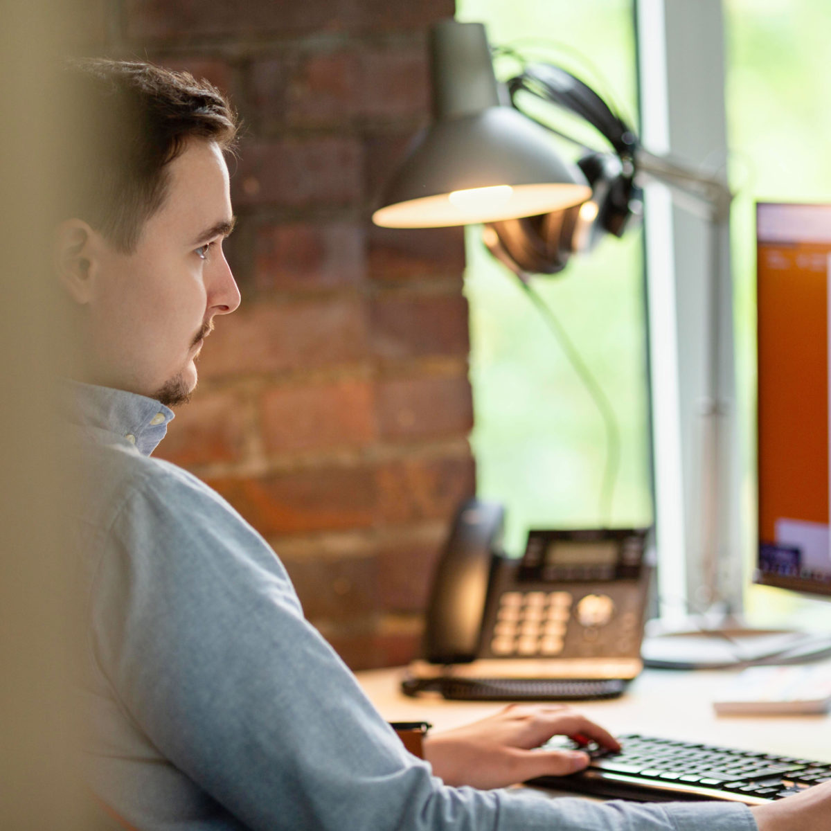 Mood Bild: Mann sitzt an Schreibtisch und arbeitet an Computer
